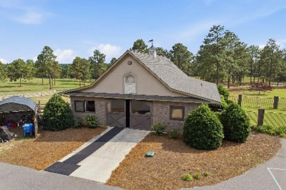 The mansion grounds include an eight-stall horse barn.