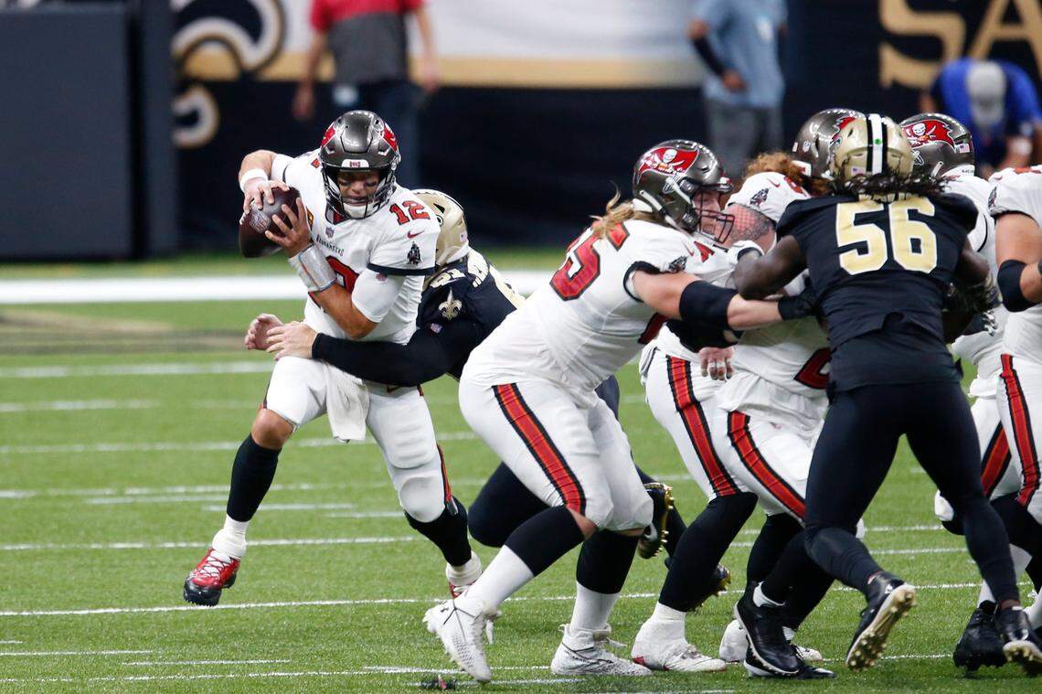 Tampa Bay quarterback Tom Brady (12) tries to avoid a sack against New Orleans in his unsuccessful debut for the Buccaneers.