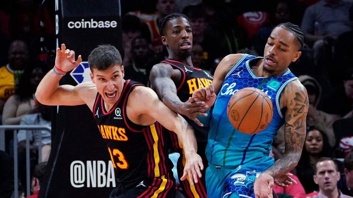 Charlotte Hornets forward P.J. Washington (25) and Atlanta Hawks guards Bogdan Bogdanovic (13) and Delon Wright (0) compete for the ball during the second half of an NBA play-in basketball game Wednesday, April 13, 2022, in Atlanta. (AP Photo/John Bazemore)