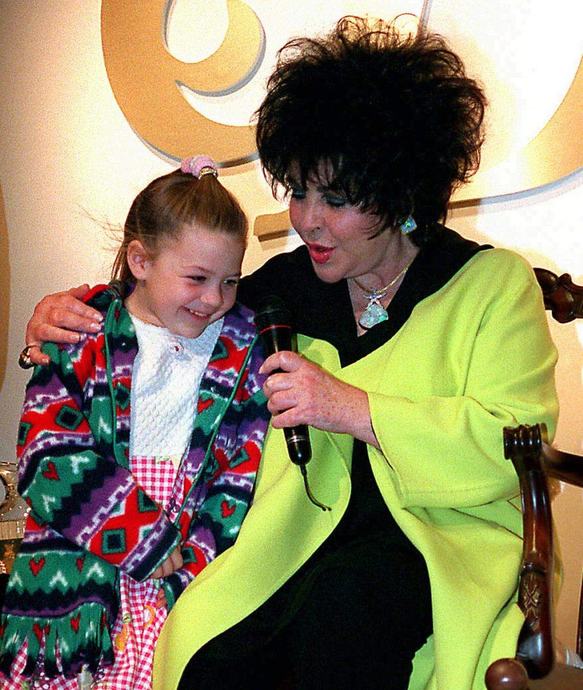 Film star Elizabeth Taylor chats with Alexandria Owsiany, 6, of Charlotte at the Eastland Mall Belk in April 1996.. Taylor and Alexandria share the same birthday, Feb. Taylor appeared at Belk to promote her perfume Black Diamonds.