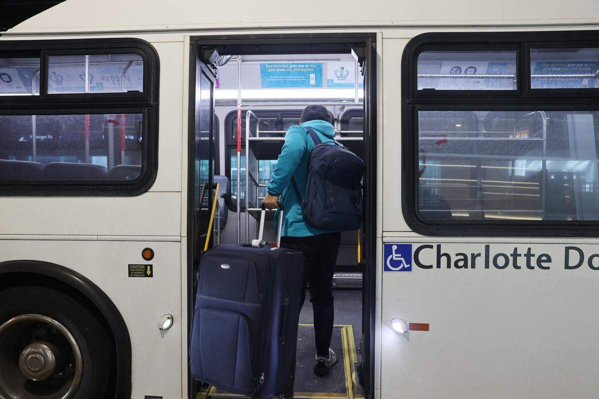 A traveler loads a shuttle to the parking area Tuesday, Jan. 27, 2026 at Charlotte Douglas Airport in Charlotte. The airport has said it is  committed to making parking dependable.