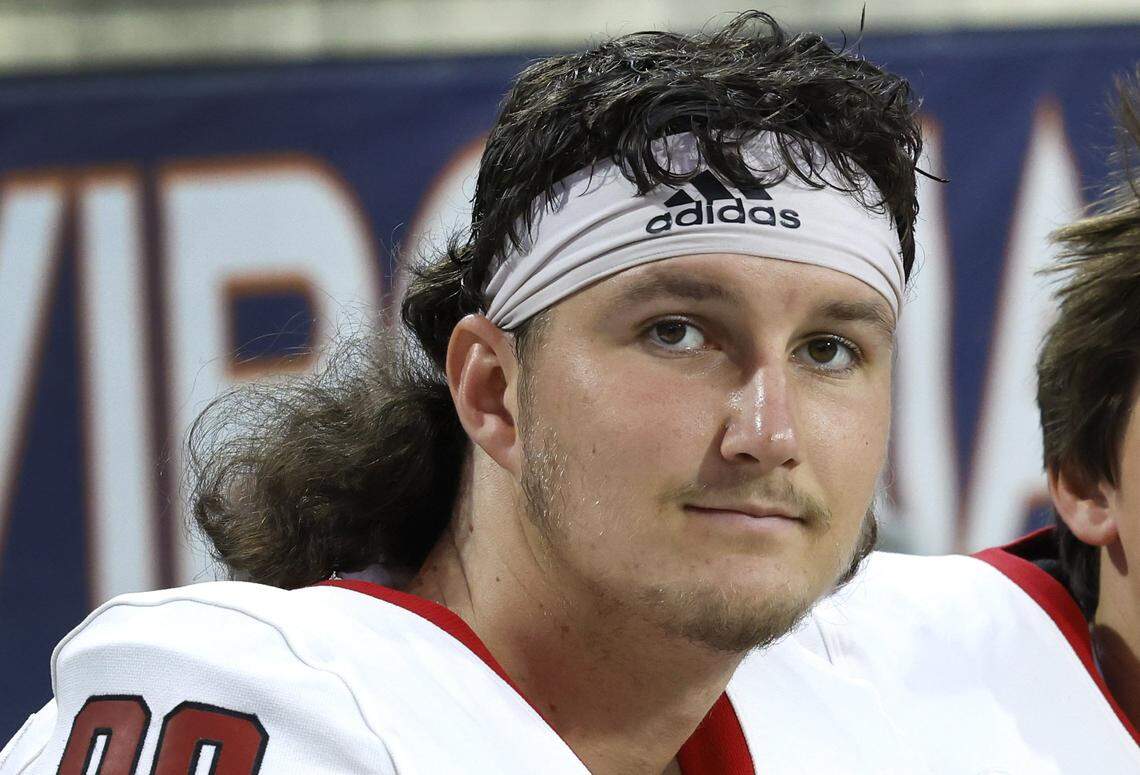 N.C. State punter Caden Noonkester (98) rest on the bench before the Wolfpack’s game against Virginia at Scott Stadium in Charlottesville, Va., Friday, Sept. 22, 2023.