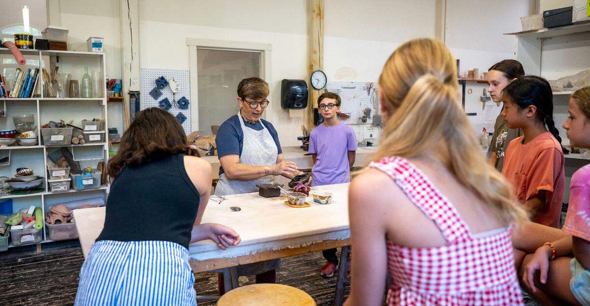 Pottery teacher Taisia Ealy demonstrates to campers their project for the day, a ceramic box, during the Summer Youth Camp at the Cain Center.