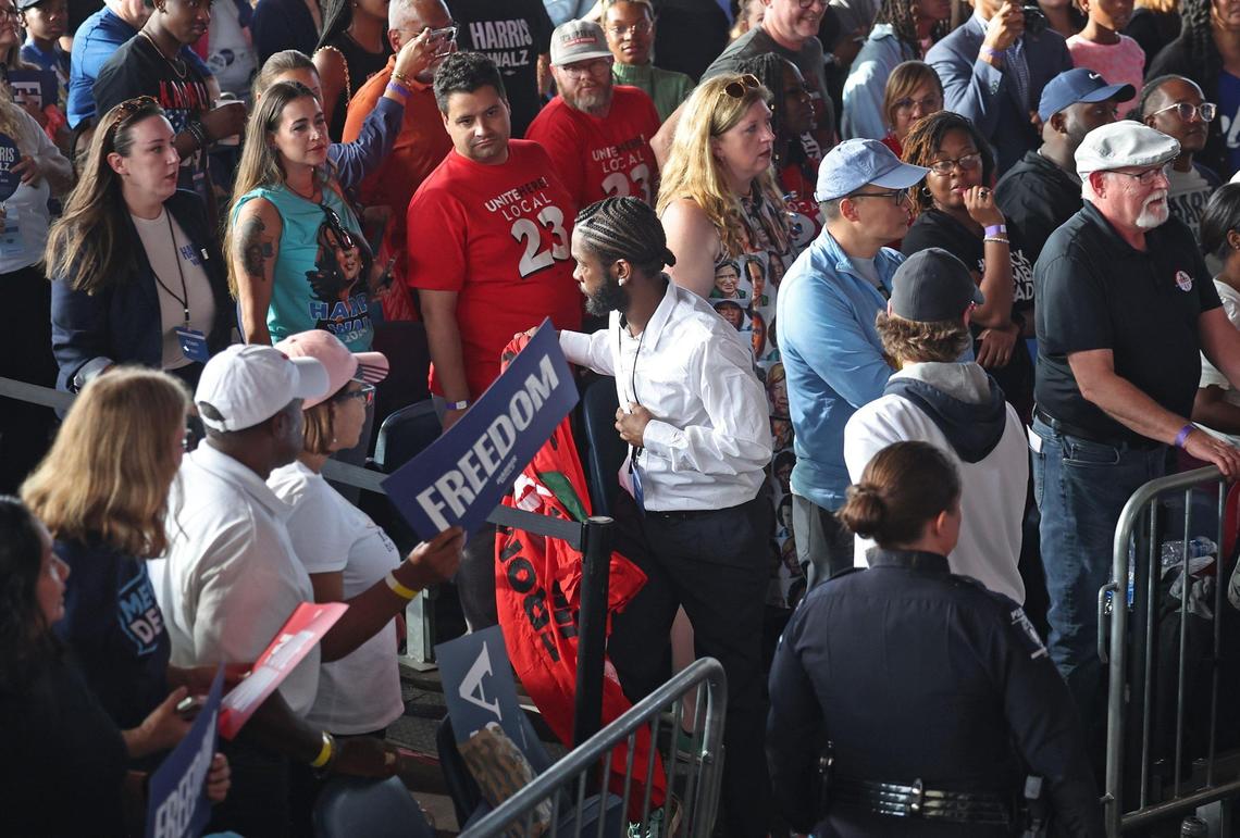 A man, center, takes away a banner that protesters held up during a rally for Vice President Kamala Harris at PNC Music Pavilion on Saturday, November 2, 2024.