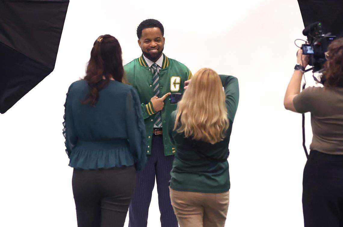 New Charlotte 49ers athletic director Kevin White proudly points to the team’s logo as he poses for photographs prior to being introduced Thursday.