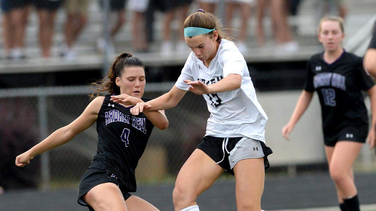 Ardrey Kell’s Ally Casey, left and Hough’s Sarah Funderburk, right, fight for control of the ball during action in the state quarterfinals on Thursday, May 26, 2022. Ardrey Kell defeated Hough 2-1.