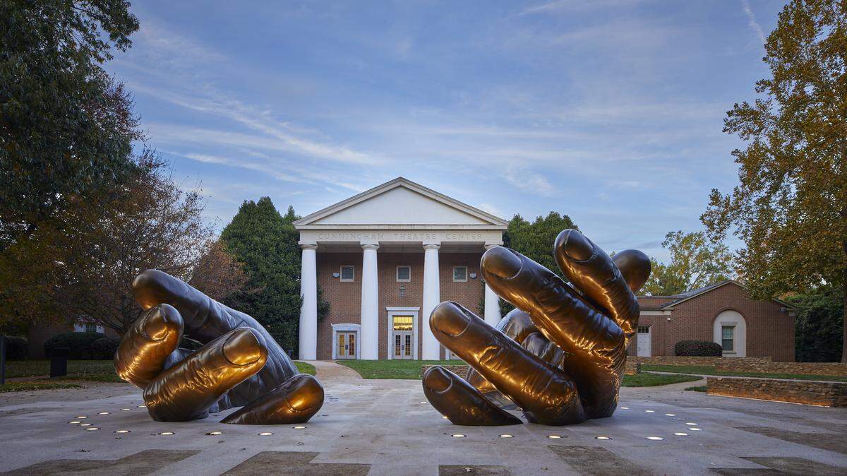 The “With These Hands” memorial, illuminated at Davidson College in this picture, will be unveiled to the public officially during an event on Thursday. It’s one of a series of steps the college has taken to reckon with its connections to slavery.