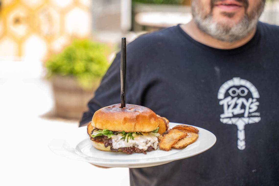 At Izzy’s at Triple C Brewing, the Izzy Burger is made with Mullis Family Farm smashed beef, white American cheese, Izzy sauce (mustard, mayo, ketchup and relish) and shredded lettuce on a brioche bun — and it is stabbed with a knife.