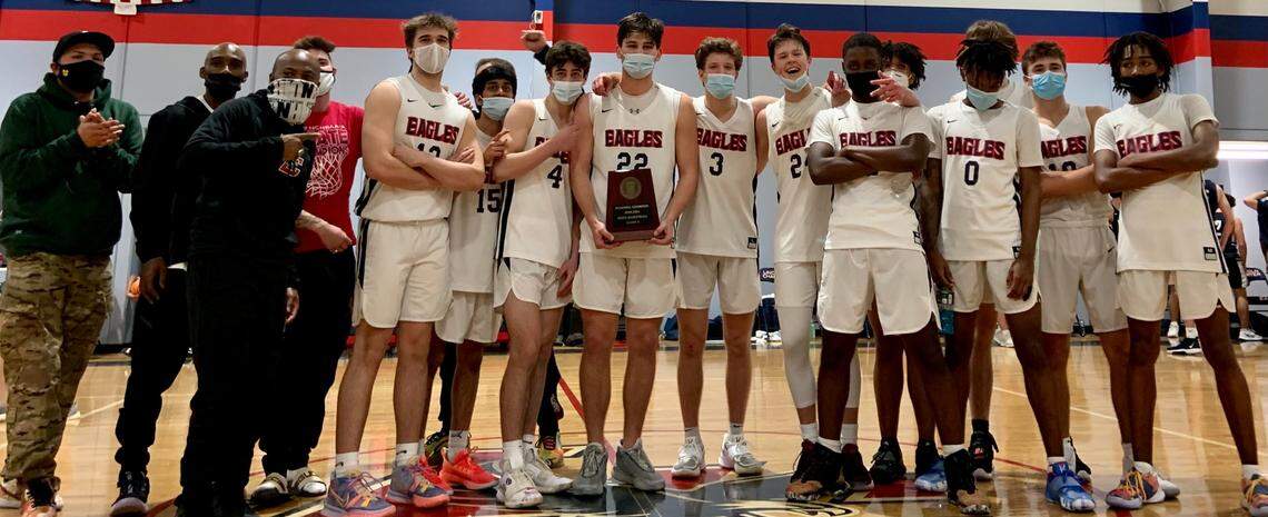 Lincoln Charter’s players and coaches surround Carter Seitz (22, holding trophy) for a team photo following the team’s win over Mount Airy in the 1A Western Regional Final on Tuesday. The team will try to win the state championship Saturday against Wilson Prep.