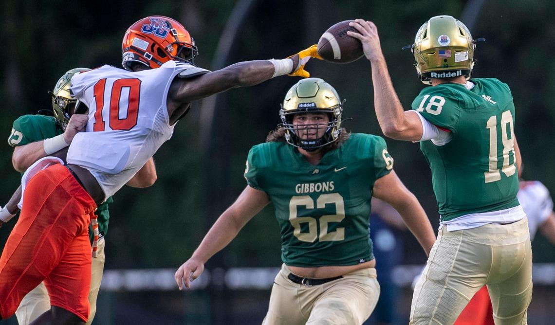 Cardinal Gibbons quarterback Connor Clark (18) is pressured by Julius Chambers’ James Pearce (10) in the first quarter on Friday, August 29, 2021 in Raleigh, N.C.