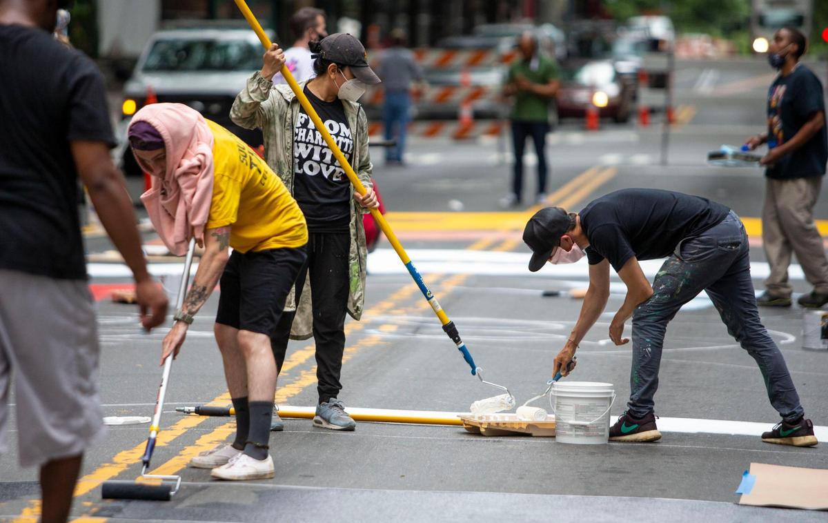 17 different artists work together on South Tryon street to paint the words “Black Lives Matter” in Charlotte, NC on Tuesday, June 9, 2020. Each artist designed their own letter to make the phrase a colorful collaboration.