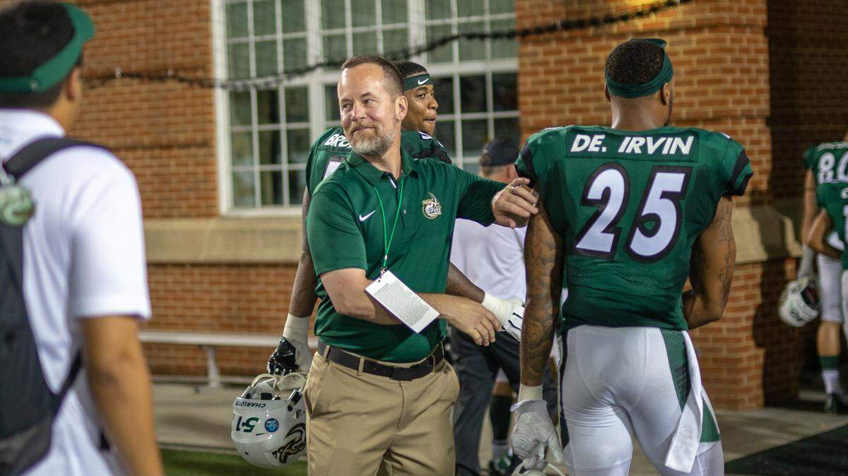 Athletic Director Mike Hill, center, has begun the search for a new football coach for the program after he notified Brad Lambert, the only coach the school has known, that he wouldn’t be retained.