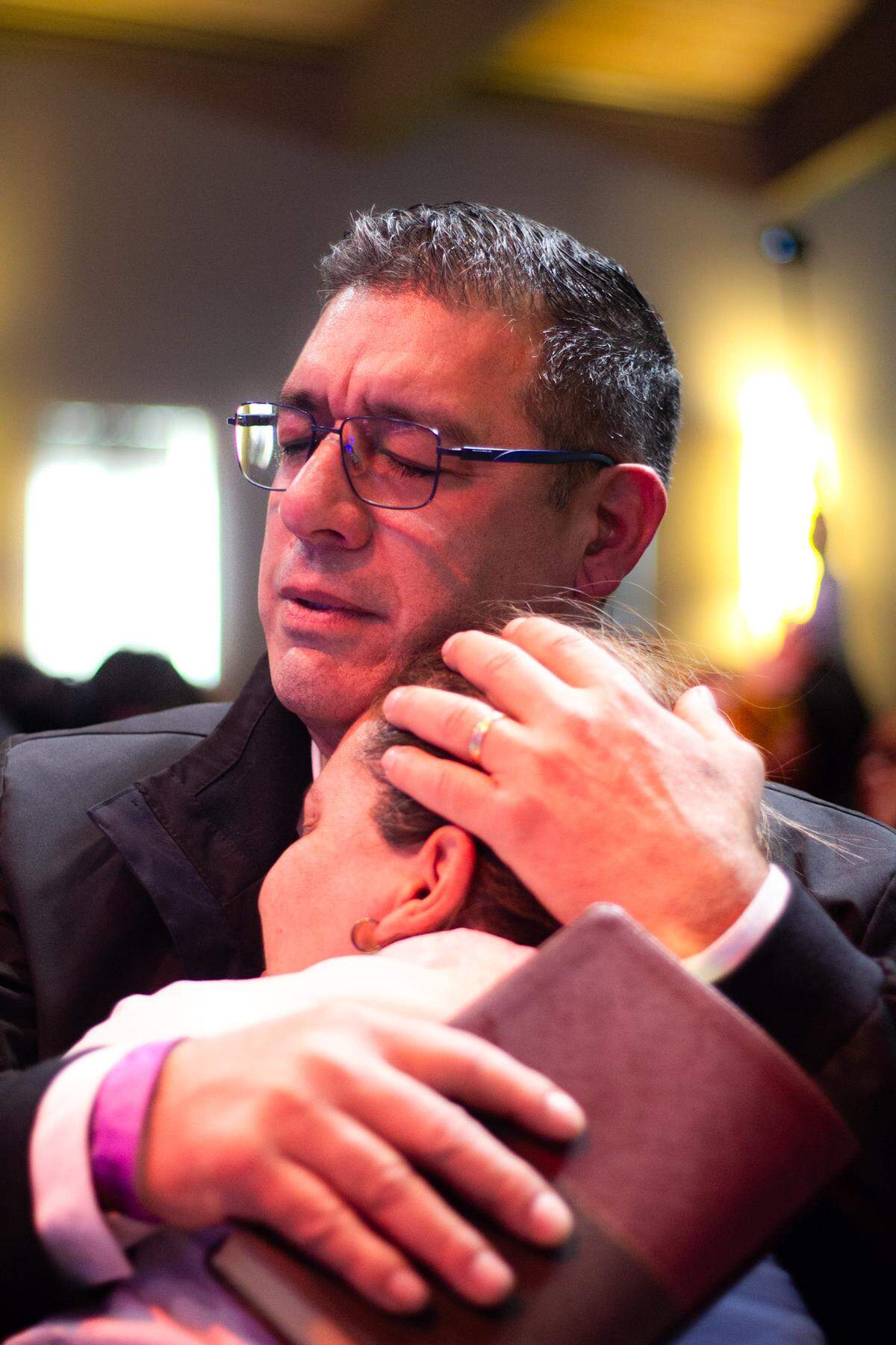 Atlanta Preacher Davud Garcia embraces a community member during prayer at Peachtree Commons