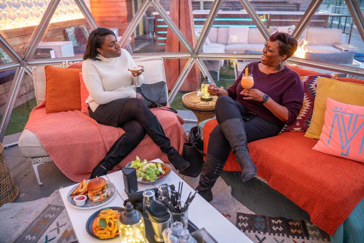 Candace Whitfield and Kim Hoefer enjoy the warmth of Merchant & Trade’s igloo seating. The uptown rooftop restaurant has two igloos that seat 10-12 people. Reservations are required.