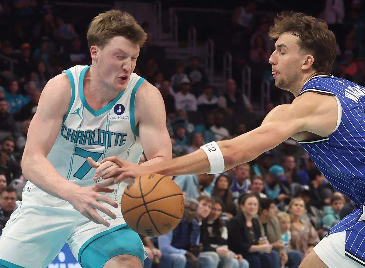 Charlotte Hornets guard Kon Knueppel, left, loses control of the ball as Orlando Magic forward Franz Wagner applies defensive pressure during action at Spectrum Center in Charlotte, North Carolina, on Oct. 30, 2025. 