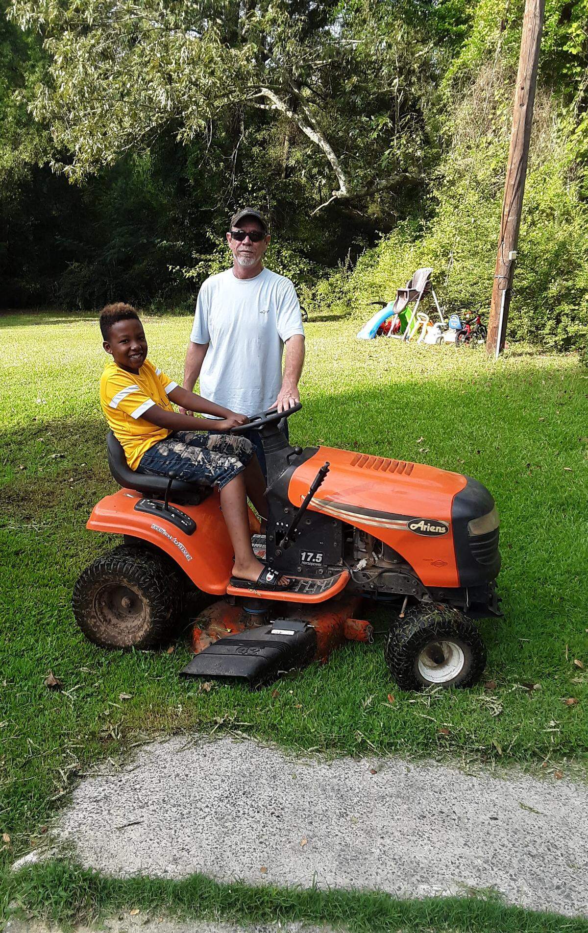 Jaylin Clyburn sits on the riding lawnmower that a supporter donated to him.