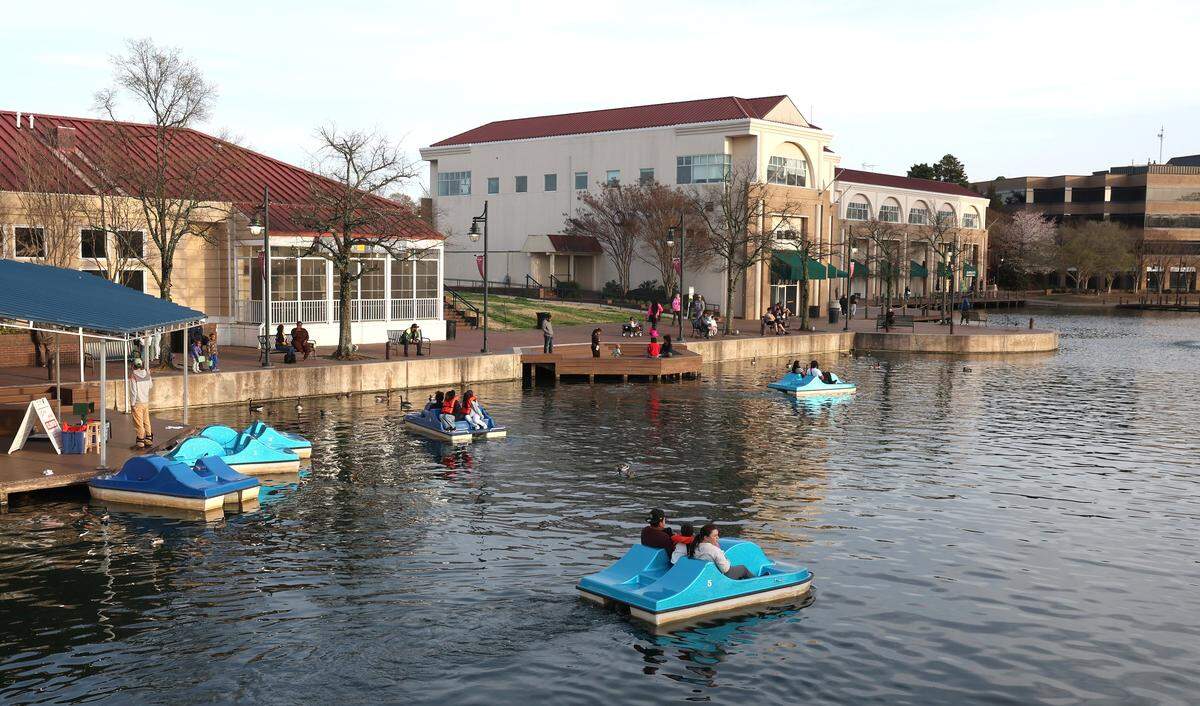 Families and couples enjoy paddleboat rides at The Boardwalk in the University City area on a recent Friday.