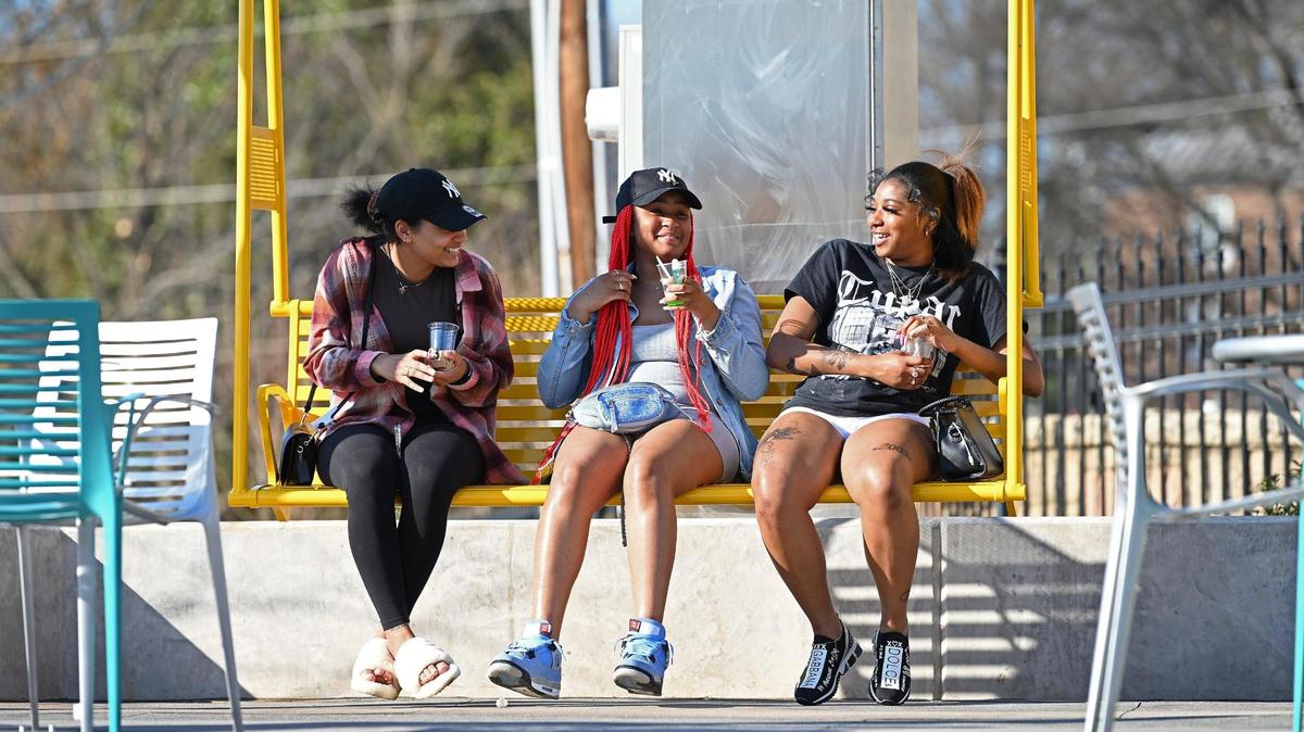 Vanessa Meyers, Titiana Peters and LaMaria Taylor enjoy a quiet afternoon on a swing at Five Points Plaza, which will officially open to the public on Saturday. The $5.5 million plaza sits close to Johnson C. Smith University and city leaders see it as a place to grab a bit to eat or sit and work.