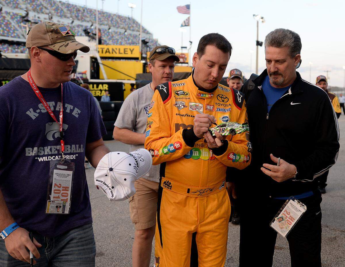 NASCAR Sprint Cup Series driver Kyle Busch, center, signs autographs for fans at Daytona International Speedway on Wednesday, February 17, 2016.