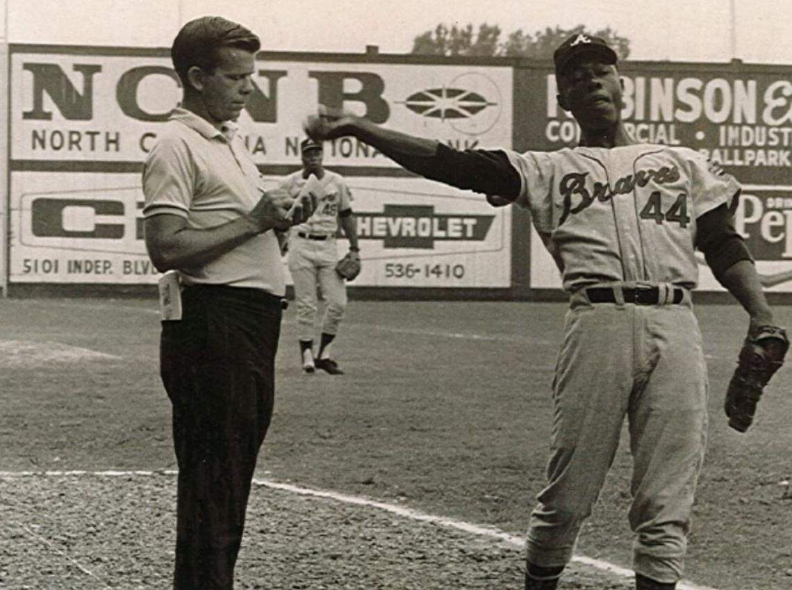 Ron Green (left) interviews baseball great Hank Aaron while Aaron warms up in an undated photo.