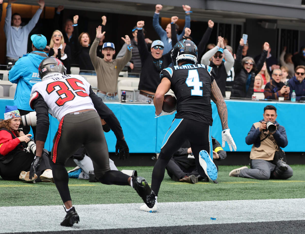 Carolina Panthers rookie Tetairoa McMillan scores a touchdown as Tampa Bay’s Jamel Dean follows Sunday at Bank of America Stadium in Charlotte.