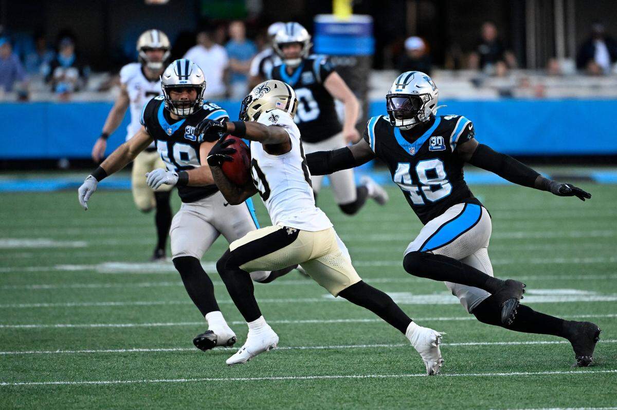 Nov 3, 2024; Charlotte, North Carolina, USA; New Orleans Saints wide receiver Jermaine Jackson (80) with the ball as Carolina Panthers linebackers Jon Rhattigan (49) and Thomas Incoom (48) defend in the fourth qarter at Bank of America Stadium. Mandatory Credit: Bob Donnan-Imagn Images