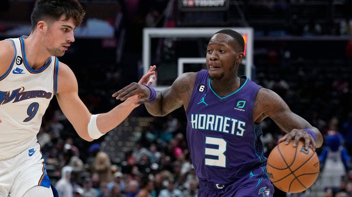 Charlotte Hornets guard Terry Rozier (3) moves past Washington Wizards forward Deni Avdija (9) during the first half of an NBA basketball game in Washington, Sunday, Nov. 20, 2022. (AP Photo/Susan Walsh)