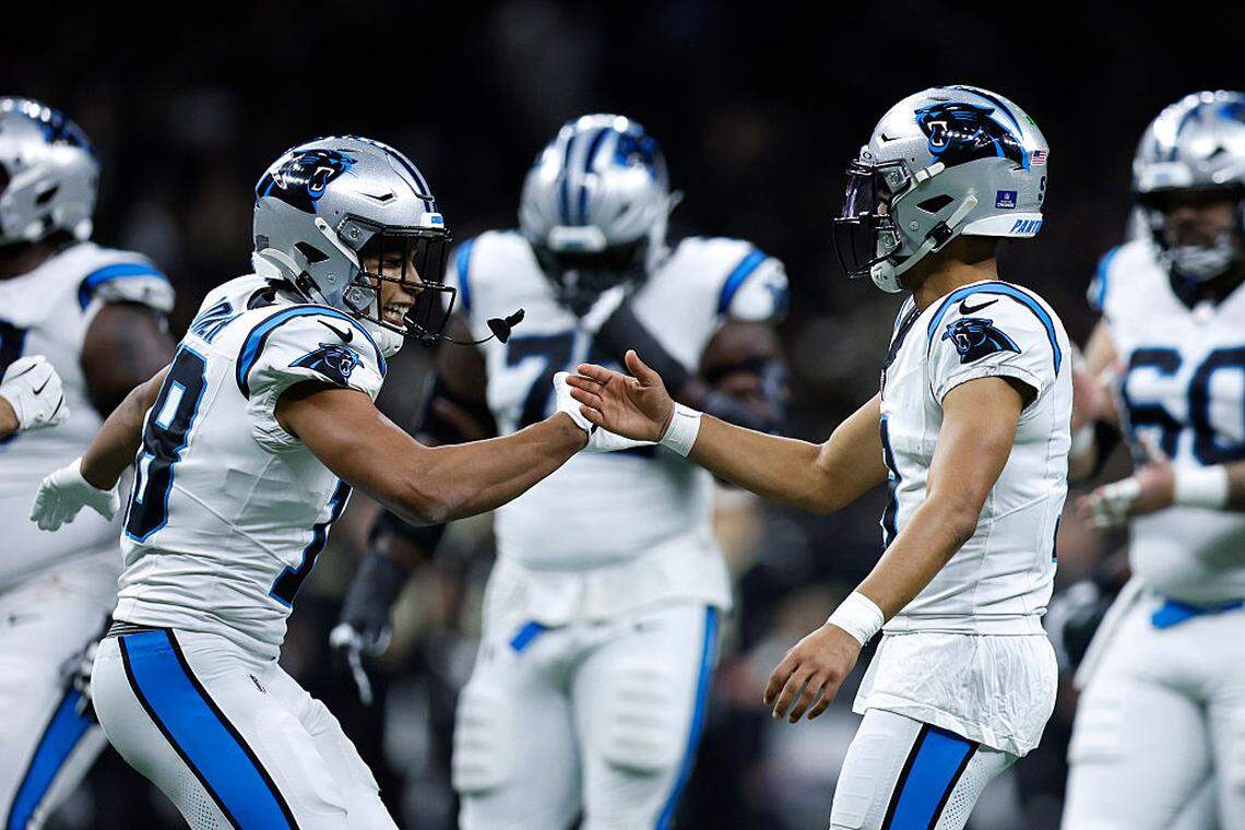 Jalen Coker, lef of the Carolina Panthers, celebrates with teammate Bryce Young, right, after connecting for a touchdown during the third quarter against the New Orleans Saints at Caesars Superdome on December 14, 2025 in New Orleans, Louisiana.