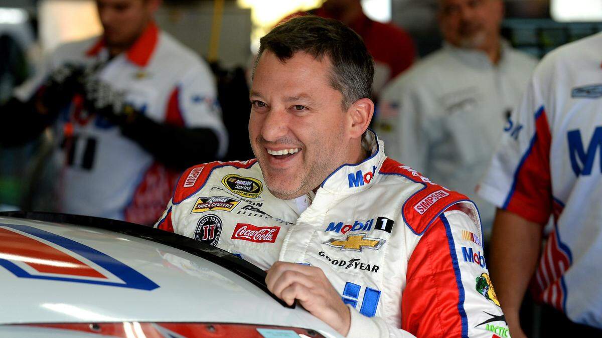 NASCAR Sprint Cup Series driver Tony Stewart laughs with members of his team as he climbs into his car for practice at Charlotte Motor Speedway in 2016. Stewart is one of the incoming 2020 inductees of the NASCAR Hall of Fame