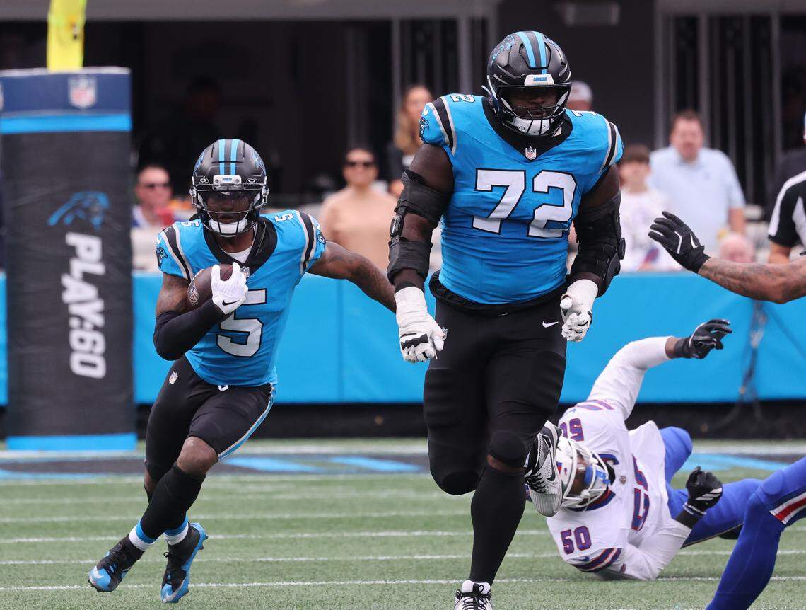 Carolina Panthers' Rico Dowdle carries the ball as Taylor Moton (72) runs ahead Sunday, Oct. 26, 2025 at Bank of America Stadium in Charlotte.
