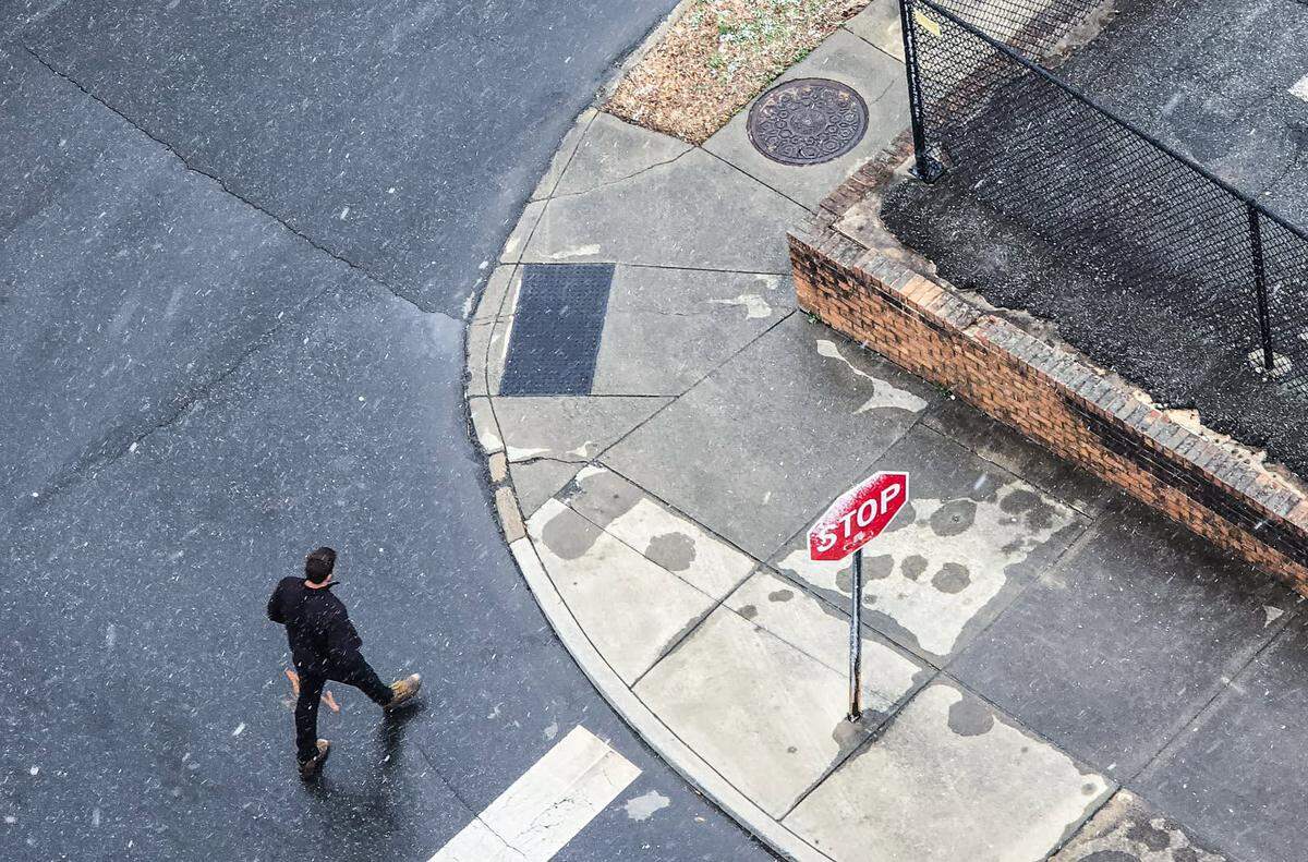 A man walks down N. Church Street in the snow in Uptown Charlotte on Wedneday, Feb. 19, 2025.