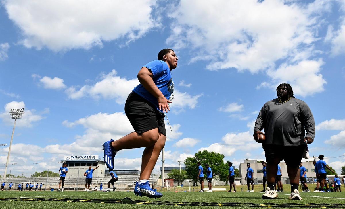 Members of the Garinger High School football team run through drills during a workout on Tuesday, April 29, 2025.