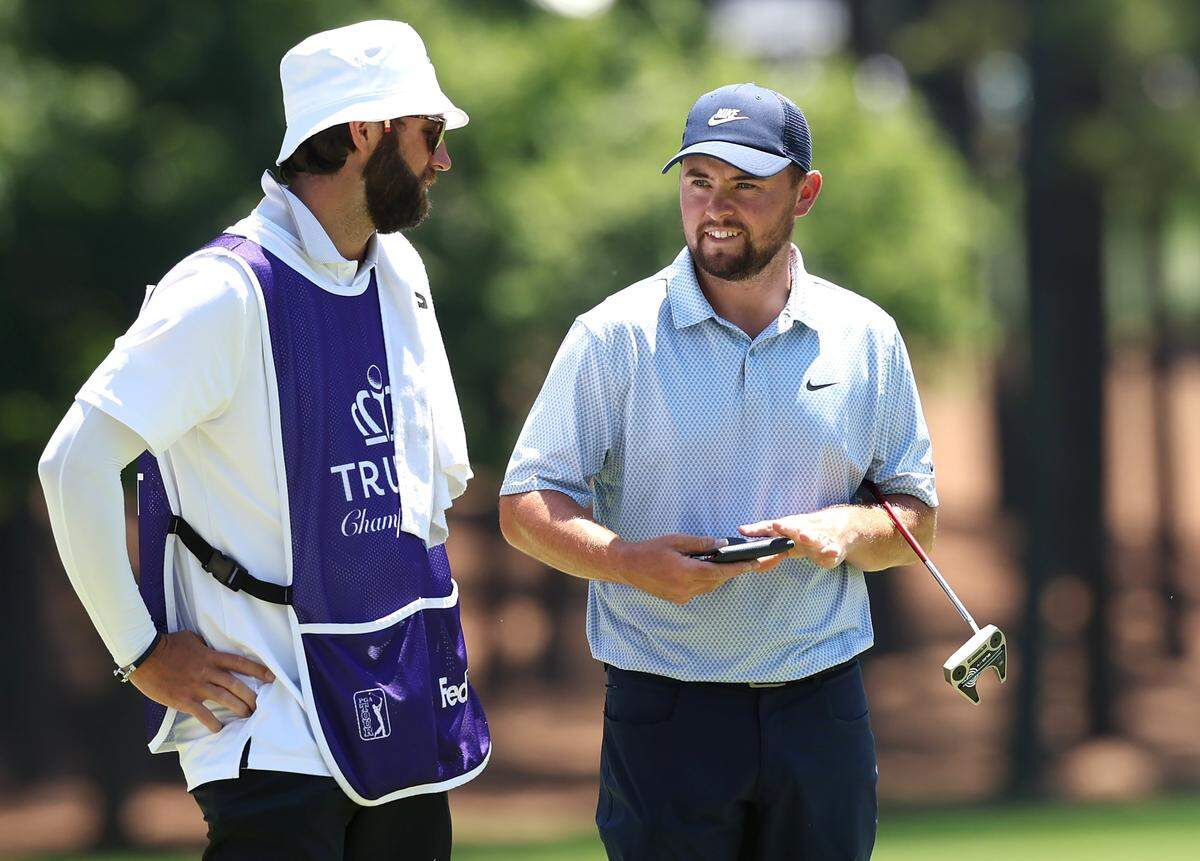 Alex Fitzpatrick, right, talks with his caddie on the second green prior to putting on the second green during the final round of the Truist Championship at Quail Hollow Club in Charlotte, NC on Sunday, May 10, 2026.