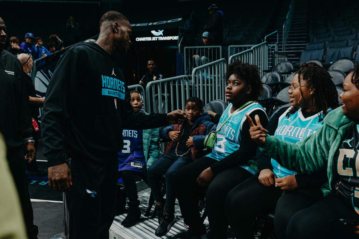 Hornets guard Terry Rozier meets with a family before a game.