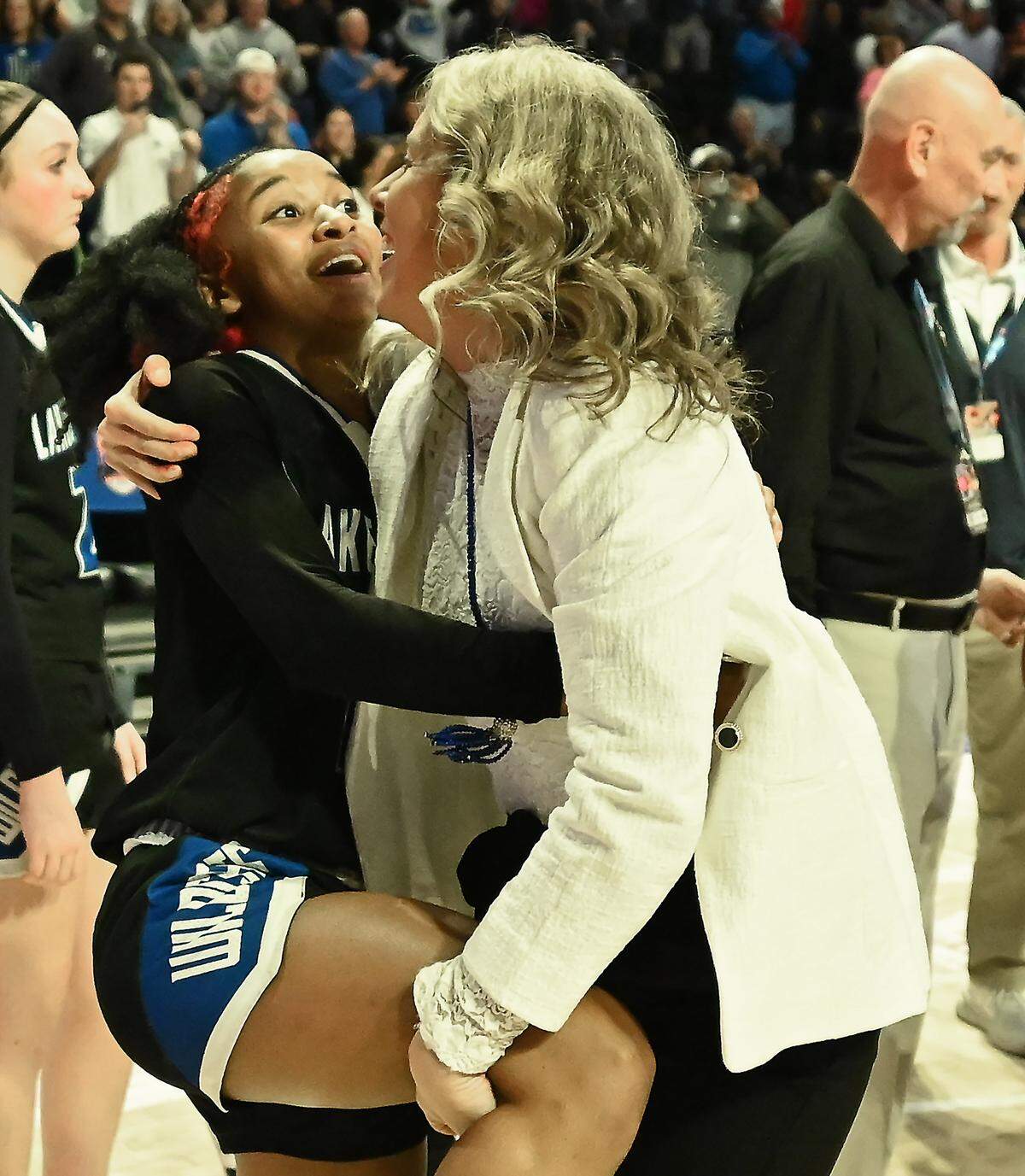 Lake Norman girls head basketball coach McKenzie Graham, right, attempts to lift Rayana Minard, left, up after Minard’s basket in the closing seconds gave the team a 43-41 victory over Wakefield in the girls NCHSAA 4A State Championship game on Saturday, March 15, 2025 at Lawrence Joel Veterans Memorial Coliseum in Winston-Salem, NC.