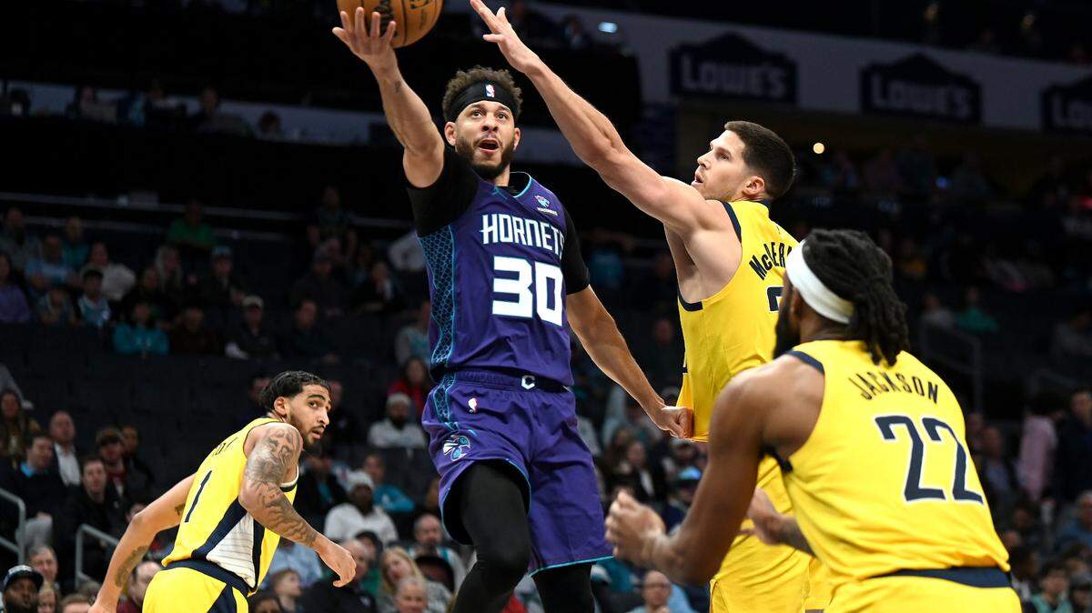 Charlotte Hornets guard Seth Curry, center, drives to the basket as Indiana Pacers forward Doug McDermott, right, attempts to slow Curry’s momentum during first half action at Spectrum Center in Charlotte, NC on Monday, February 12, 2024.