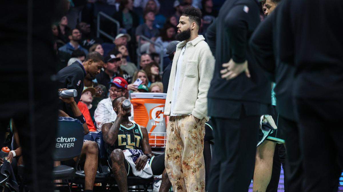 Hornets forward Cody Martin, second from left, stands on the sidelines during a timeout during the game against the 76ers at Spectrum Center on Friday, March 17, 2023.