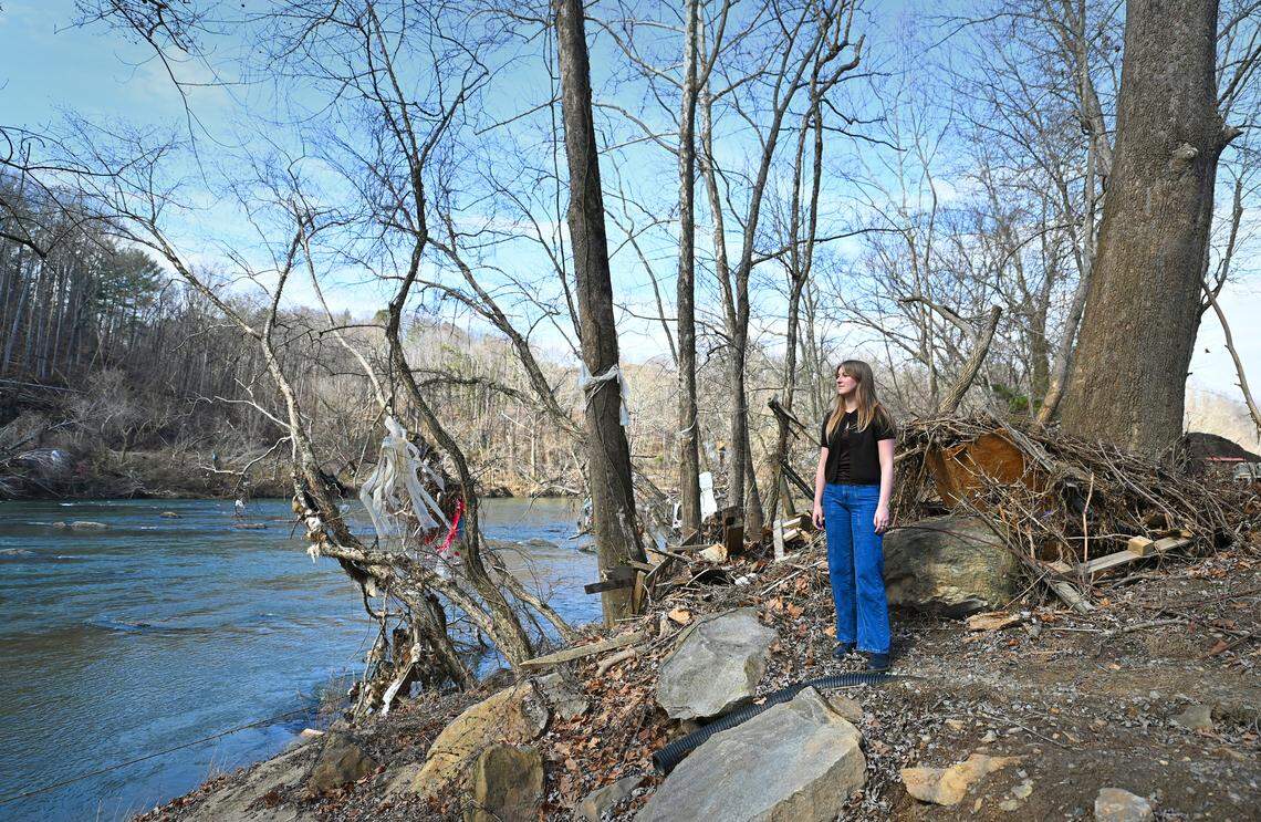 Sarah Schwindt, administrative manager for Zen Tubing in Asheville, NC., stands near the landing where tubers used to land following their trip down the French Broad River on Wednesday, February 5, 2025. Debris still hangs from the trees and lines the banks following Hurricane Helene in late September 2024. River-side businesses are desperate to get out on the water, but Helene’s damage was more than anyone expected. Zen Tubing will be operating from a second site this season.