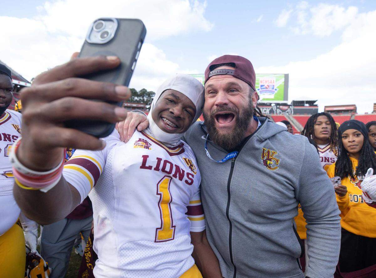 West Charlotte’s Michael Griffin Jr. (1) celebrates with head coach Sam Greiner (right). West Charlotte would defeat Seventy-First 17-14 in the NCHSAA 3A state championship game at Carter Finley Stadium Saturday December 21, 2024.