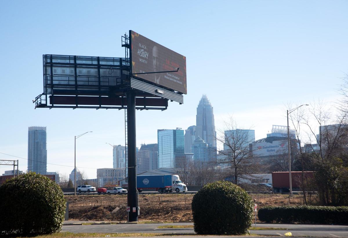 A view of the Charlotte skyline beneath a billboard off of I-77 in Charlotte.