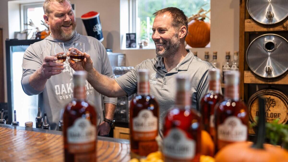 Matt Simpkins, left, and Tom Bogan cheers before sampling a whiskey at Oaklore Distilling Co. in Matthews, N.C., on Tuesday, September 30, 2025.