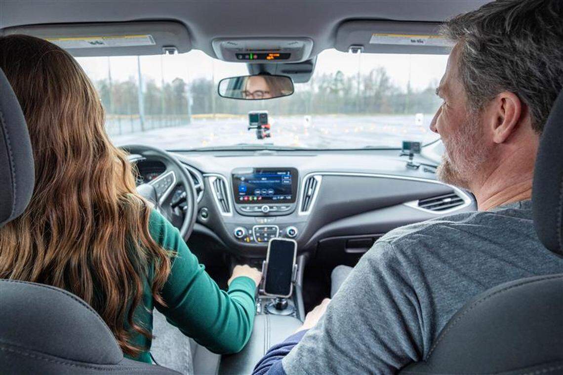 Allie Miller, a 17-year-old high school junior, drives on an obstacle course set up by BRAKES while former NASCAR star Dale Earnhardt Jr. watches.