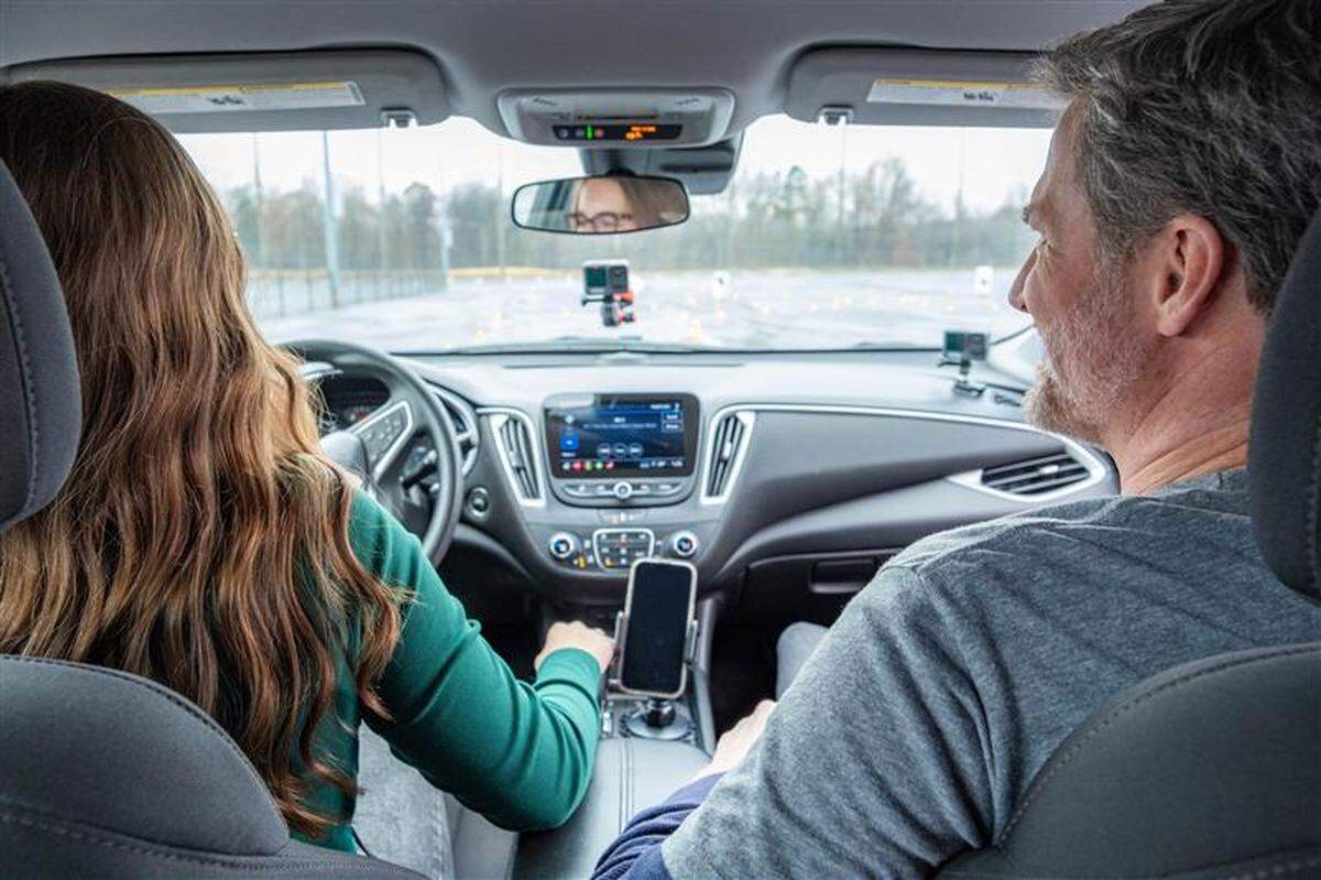 Allie Miller, a 17-year-old high school junior, drives on an obstacle course set up by BRAKES while former NASCAR star Dale Earnhardt Jr. watches.
