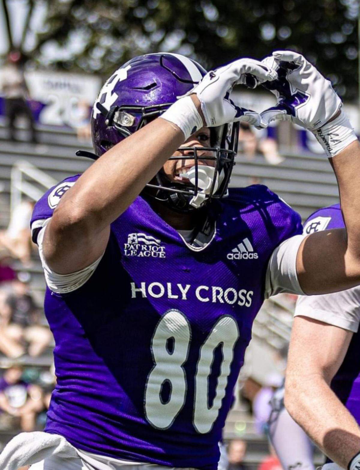 Jalen Coker, previously a wide receiver at Holy Cross, throwing up the heart sign, which is also the symbol of the Love Like Adam Foundation.