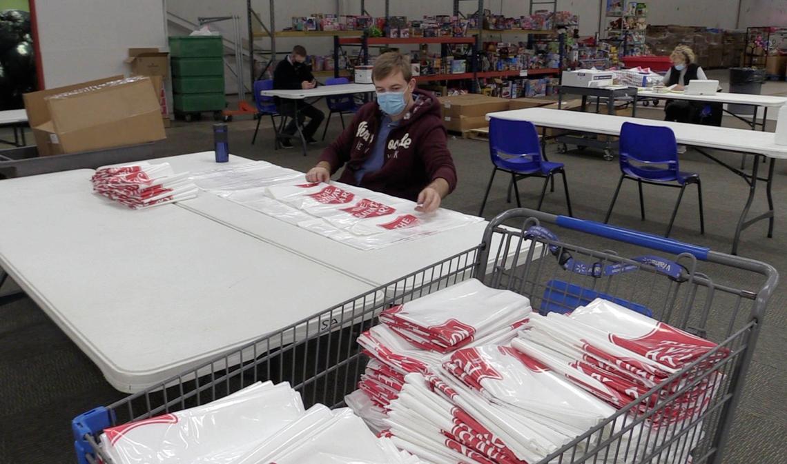 Volunteer Serge Divachuk folds family gift bags at The Salvation Army’s Christmas Center on Thursday, November 19, 2020. 