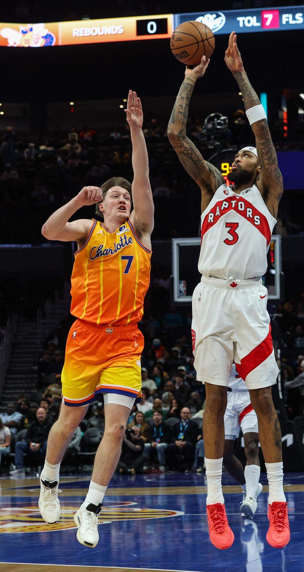 Hornets guard Kon Knueppel, left, throws an arm up as Raptors forward Brandon Ingram takes a shot during the game at Spectrum Center in Charlotte, North Carolina, on Saturday, Nov. 29, 2025.
