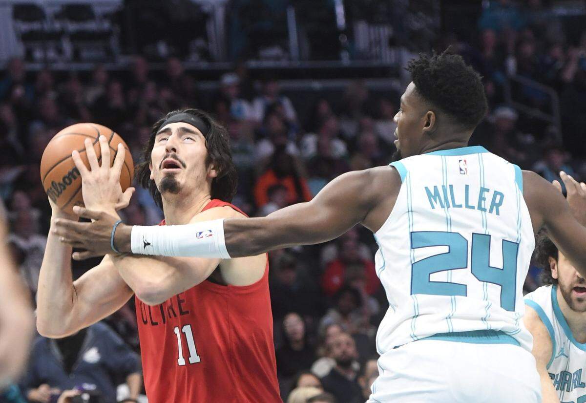 Charlotte Hornets guard Brandon Miller (24) fouls Miami Heat forward Jaime Jaquez Jr. (11) during the first half at the Spectrum Center.