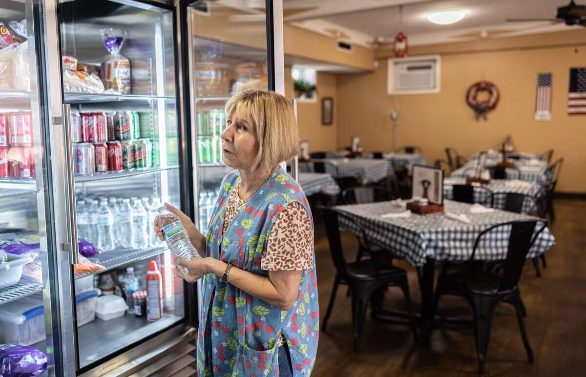 Julie Yawn, owner of Chat-n-Nibble, holds up a bottle of water that she has for customers who won’t drink city water.