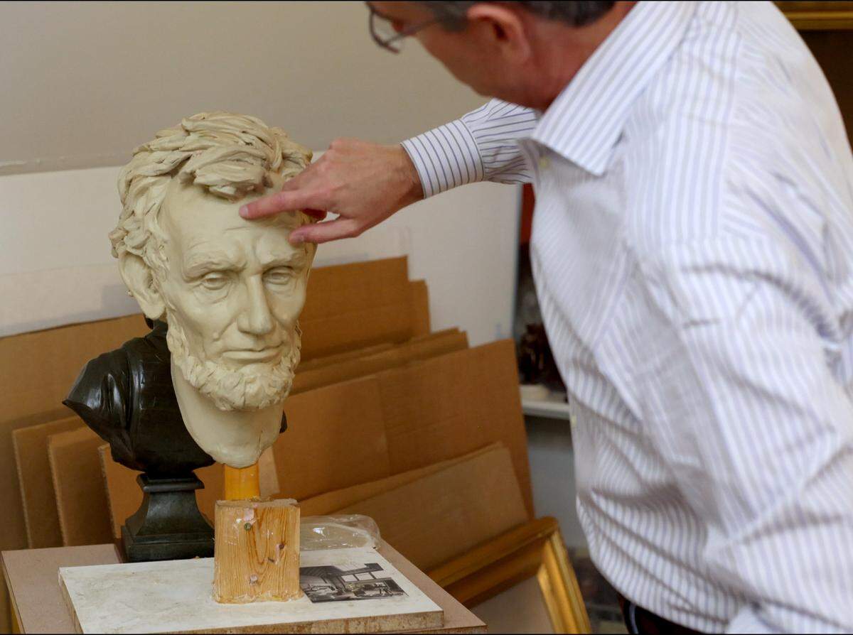 Charlotte sculptor Chas Fagan examines a clay model of a bust of President Abraham Lincoln he sculpted. The model sits in Fagan’s home studio. The life-size bronze bust was commissioned by the Union League Club in New York City.