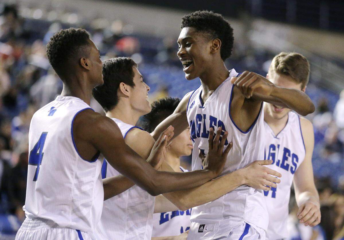 Jalen McDaniels, center, celebrates with high school teammates. McDaniels went to high school in Washington state, and it was there he secretly recorded two female classmates performing sexual acts without their consent, according to court documents.